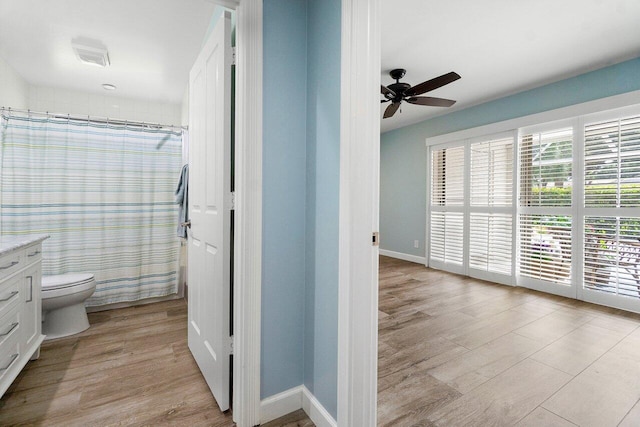 bathroom with vanity, toilet, wood-type flooring, and ceiling fan