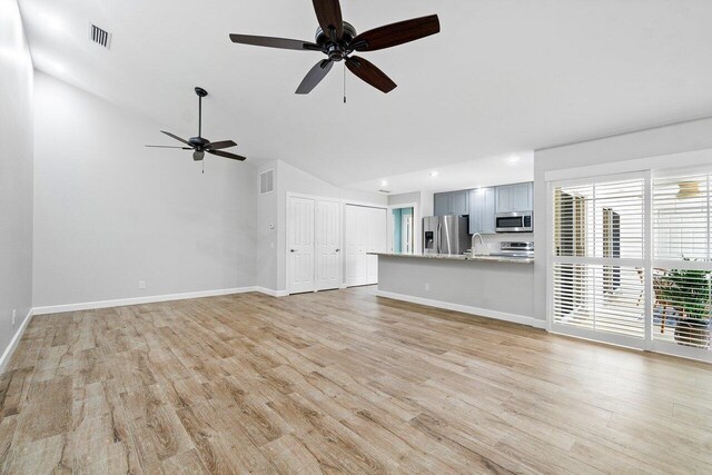 unfurnished living room with lofted ceiling, ceiling fan, light wood-type flooring, and sink