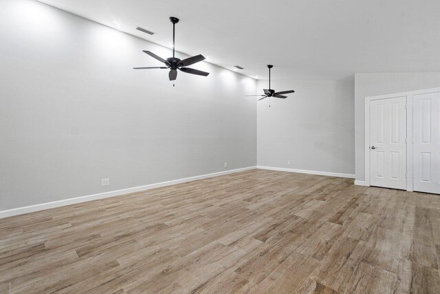 empty room featuring lofted ceiling, ceiling fan, and light hardwood / wood-style floors