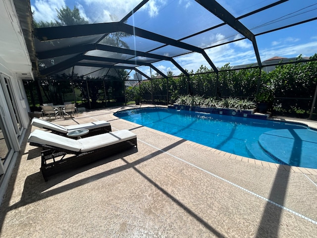 view of swimming pool featuring a lanai and a patio