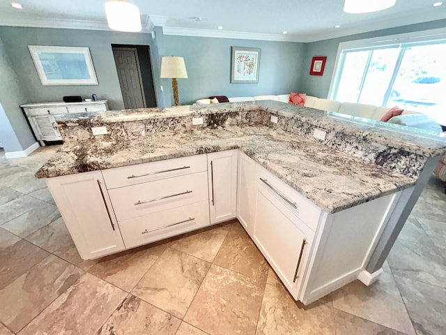 kitchen featuring crown molding, light stone counters, and white cabinetry