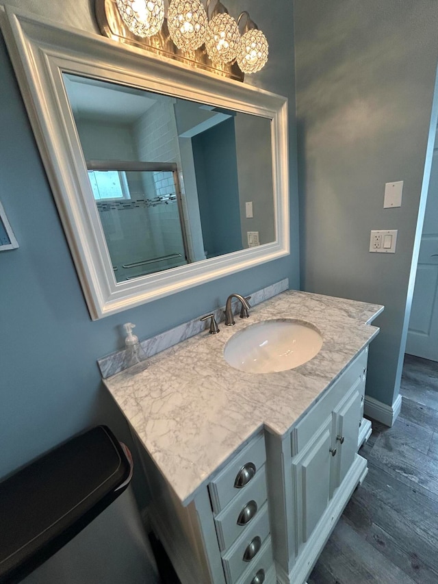 bathroom featuring hardwood / wood-style floors, walk in shower, and vanity