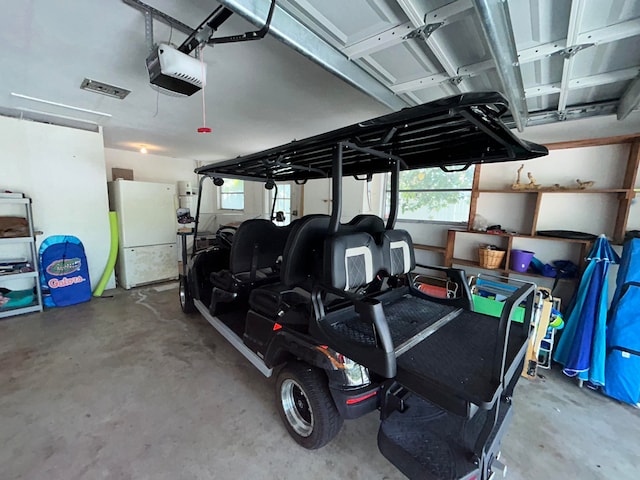 garage featuring white refrigerator and a garage door opener