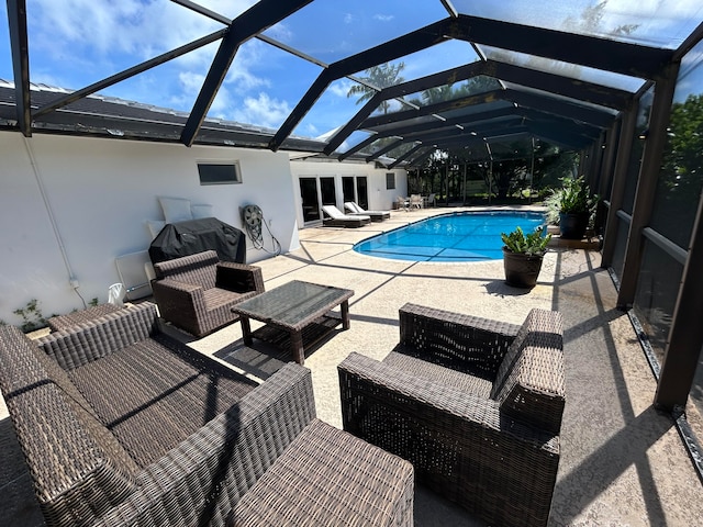 view of swimming pool with outdoor lounge area, a patio area, and glass enclosure