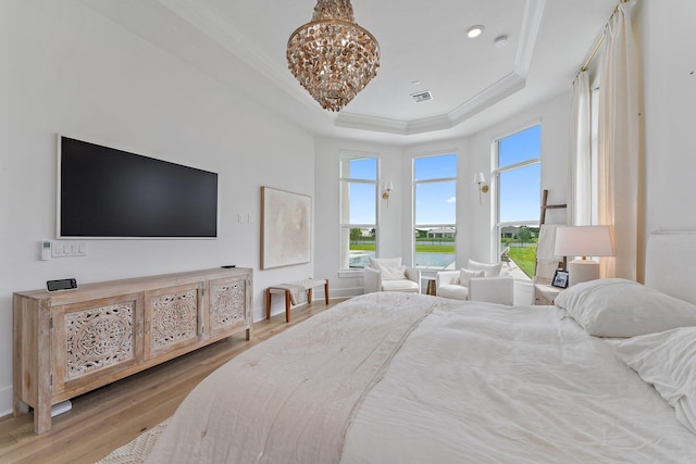 bedroom featuring ornamental molding, wood finished floors, baseboards, a raised ceiling, and a chandelier