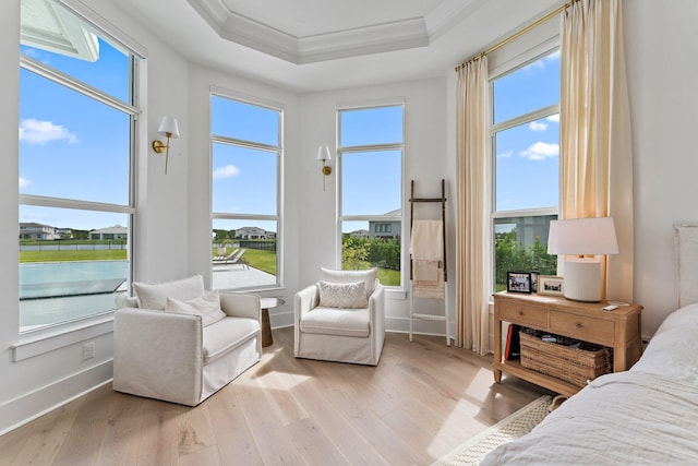 bedroom featuring light hardwood / wood-style flooring, ornamental molding, a raised ceiling, and multiple windows