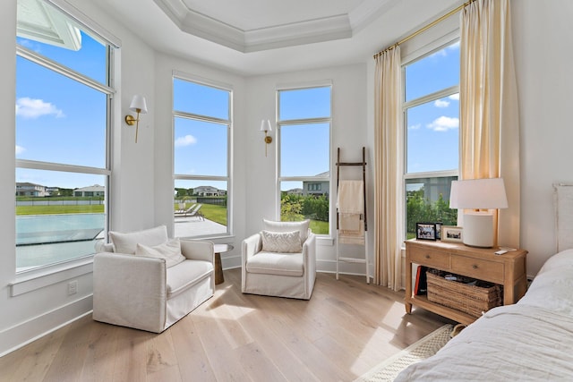 bedroom with a raised ceiling, ornamental molding, baseboards, and wood finished floors