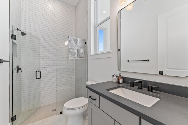 bathroom with vanity, toilet, and a shower with shower door