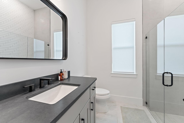 bathroom featuring vanity, toilet, and a shower with shower door