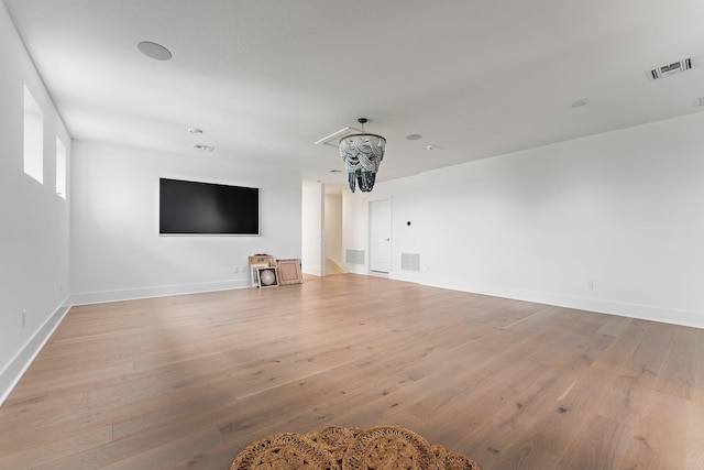 unfurnished living room with baseboards, light wood-style flooring, and visible vents