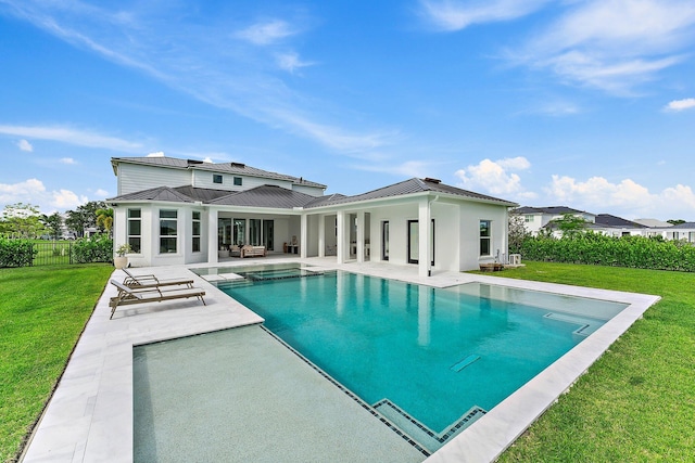 back of property featuring a fenced in pool, a patio area, a standing seam roof, a yard, and metal roof