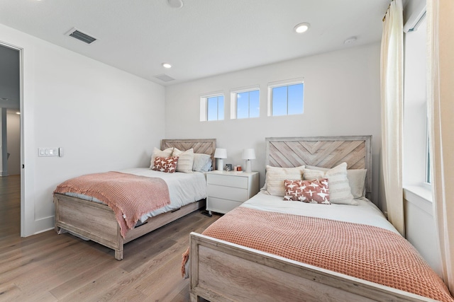 bedroom with recessed lighting, baseboards, visible vents, and wood finished floors