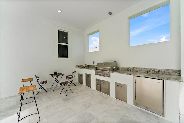 view of patio / terrace with exterior kitchen, a grill, and sink