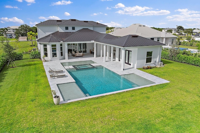 back of house featuring a yard, a patio, an outdoor living space, and metal roof