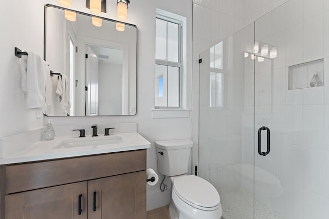 full bath featuring vanity, toilet, and a shower stall