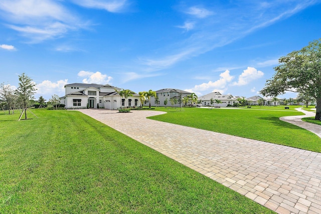 view of home's community with a yard and decorative driveway