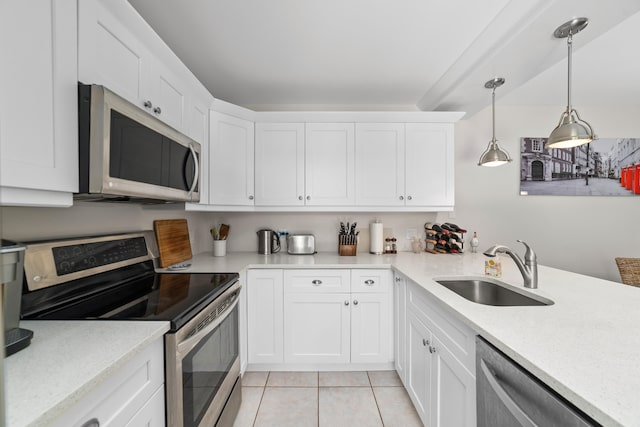 kitchen with stainless steel appliances, pendant lighting, sink, and white cabinetry