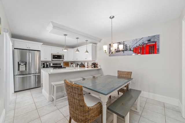 dining room with a notable chandelier, sink, and light tile patterned floors