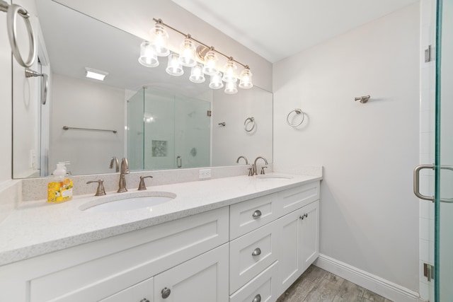 bathroom with a shower with door, hardwood / wood-style floors, and vanity