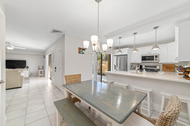 tiled dining space featuring ceiling fan with notable chandelier