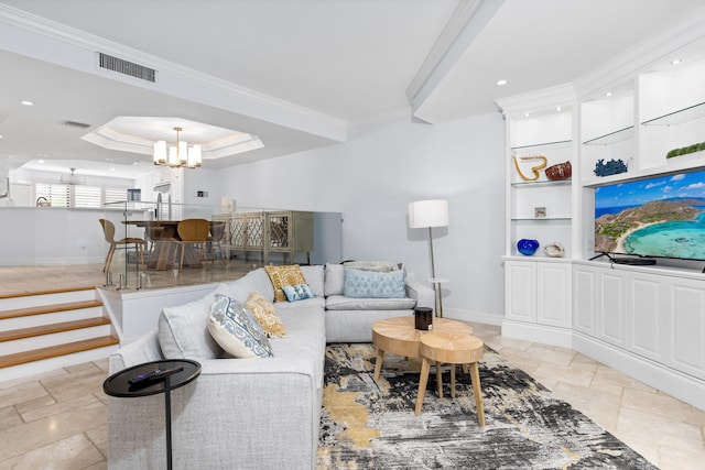 living room featuring a notable chandelier, a raised ceiling, and ornamental molding