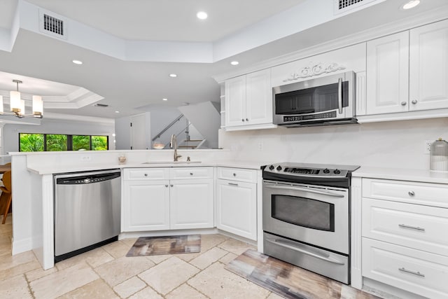 kitchen with white cabinets, sink, appliances with stainless steel finishes, and a raised ceiling