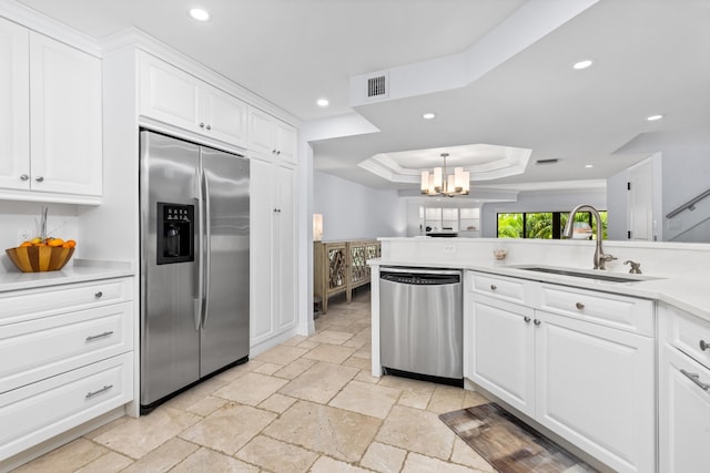 kitchen with sink, a notable chandelier, white cabinets, a raised ceiling, and appliances with stainless steel finishes