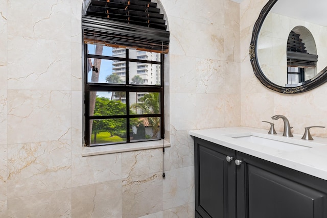 bathroom with vanity and tile walls