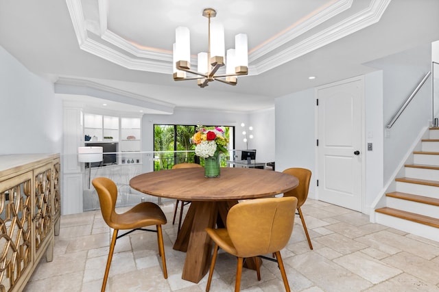 dining area with a notable chandelier, a tray ceiling, and crown molding