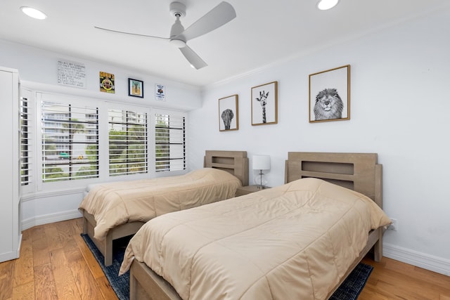 bedroom with light hardwood / wood-style flooring, ceiling fan, and ornamental molding