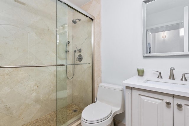 bathroom with walk in shower, vanity, and toilet