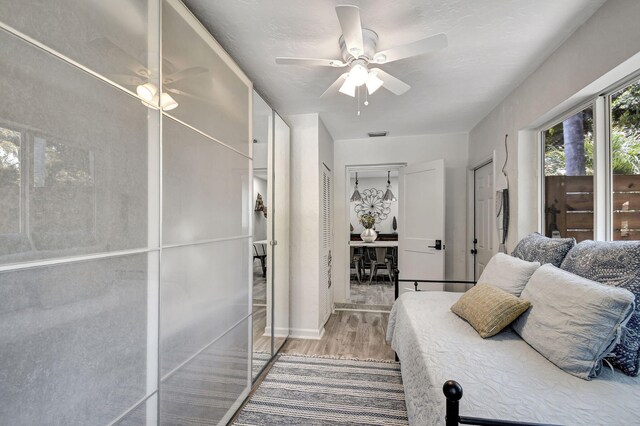 bedroom with visible vents, wood finished floors, and a ceiling fan