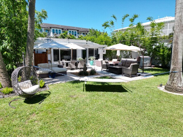 rear view of house with a patio area, a lawn, outdoor lounge area, and fence