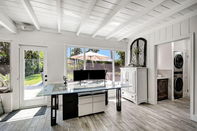 interior space featuring stacked washer and dryer, light wood-style flooring, white cabinets, and beam ceiling