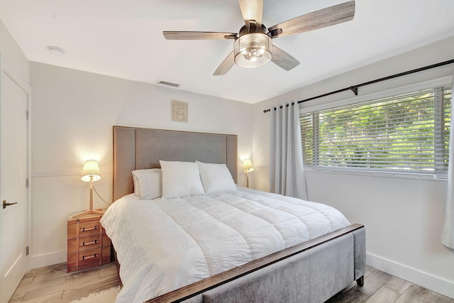 bedroom with baseboards, visible vents, ceiling fan, and light wood finished floors