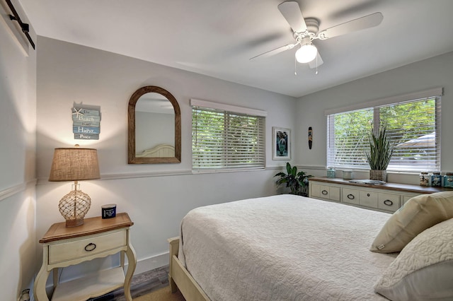 bedroom with ceiling fan and a barn door