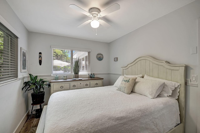 bedroom with ceiling fan, wood finished floors, and baseboards