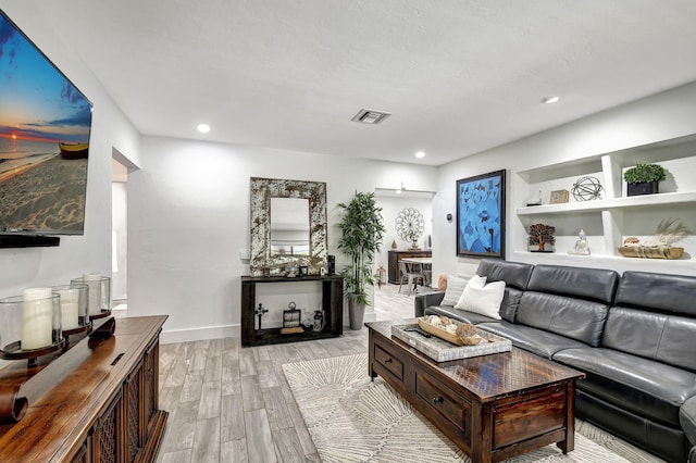 living room featuring baseboards, recessed lighting, visible vents, and light wood-style floors