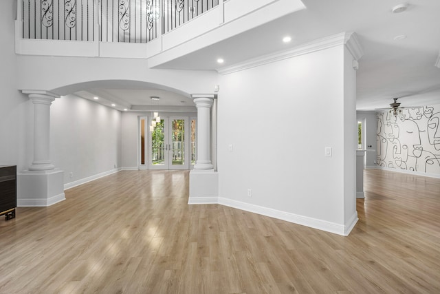 unfurnished living room featuring ceiling fan, decorative columns, and light hardwood / wood-style floors