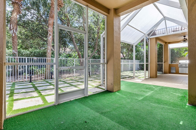 unfurnished sunroom featuring ceiling fan and vaulted ceiling