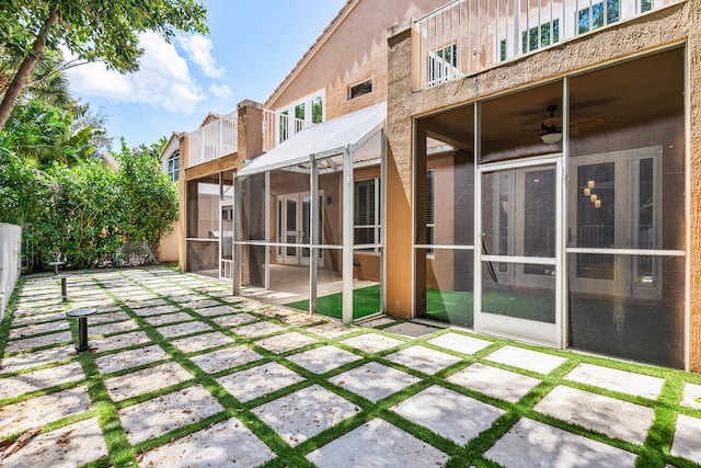 back of property featuring ceiling fan and a patio