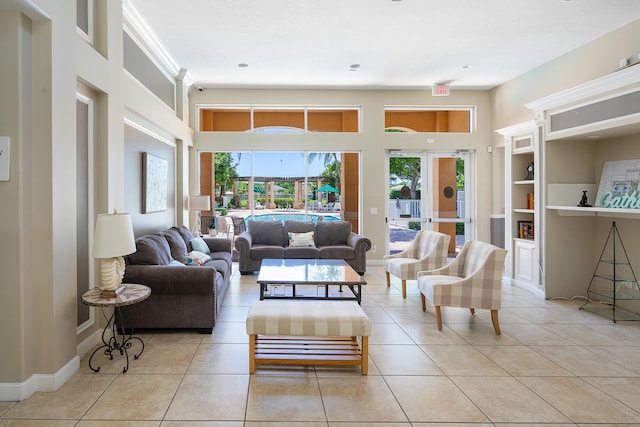 living room featuring built in features, light tile patterned floors, and a healthy amount of sunlight