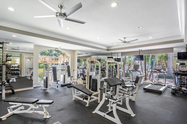 gym with a tray ceiling, ceiling fan, crown molding, and a textured ceiling