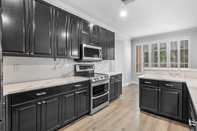 kitchen with light hardwood / wood-style flooring, crown molding, stainless steel appliances, decorative backsplash, and light stone counters