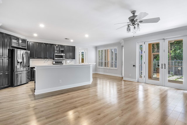 kitchen featuring crown molding, stainless steel appliances, a center island, ceiling fan, and light hardwood / wood-style floors