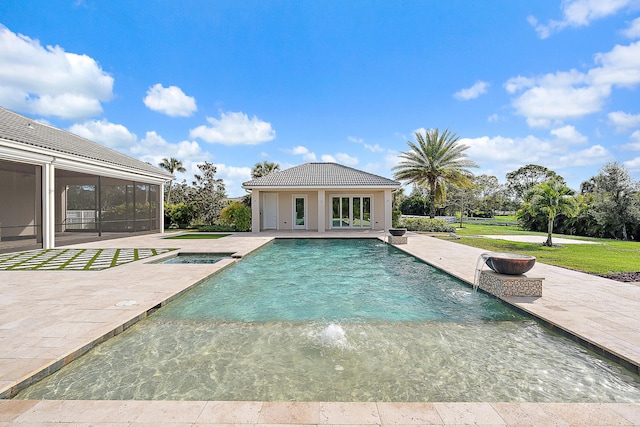 view of swimming pool with a patio area, an outdoor structure, pool water feature, and an in ground hot tub