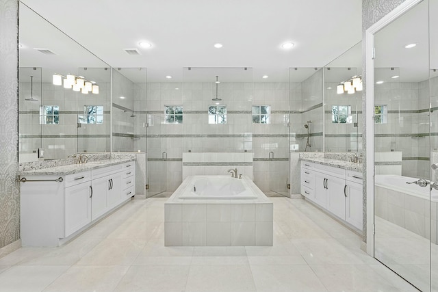 bathroom with visible vents, a stall shower, two vanities, and a sink