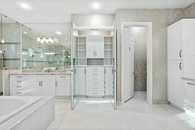 full bath with wallpapered walls, a closet, tile patterned flooring, tiled shower, and vanity