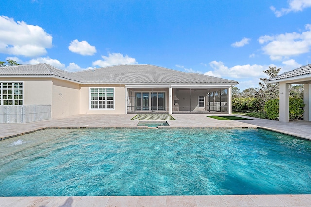 view of pool with a sunroom, a jacuzzi, and a patio area