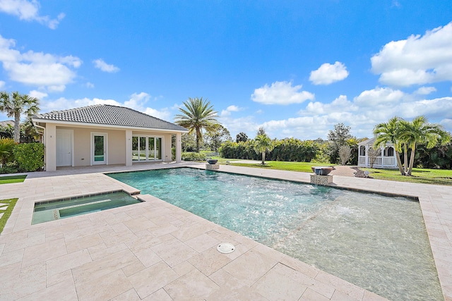 view of pool featuring an in ground hot tub, an outdoor structure, and a patio